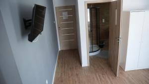 a bathroom with a toilet and a television on a wall at Pokoje Green House in Ustroń +102 photos