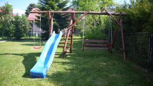 a playground with a blue slide in a yard at Pokoje Green House in Ustroń