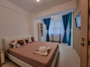 a bedroom with a bed with blue curtains and a door at Promenada 1-4 in Mamaia Sat/Năvodari