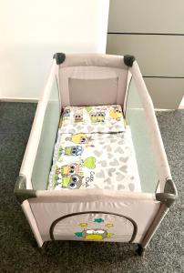 a baby crib with a hello kitty blanket at Apartmán Majerův dvůr in Rožnov pod Radhoštěm