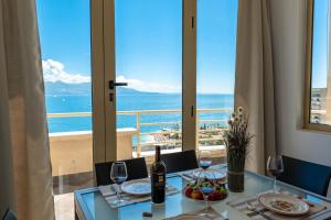 a table with wine glasses and a view of the ocean at ERAL Apart-Hotel & Penthouse in Sarandë