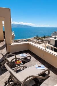 a balcony with tables and chairs and the ocean at ERAL Apart-Hotel & Penthouse in Sarandë