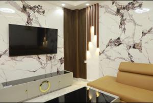 a living room with a television on a wall at Belgaid résidence OREVA in Oran