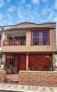 a large brick house with a balcony on top of it at Quimbaya Private House in Quimbaya