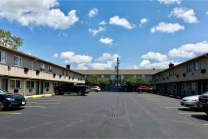 a parking lot with cars parked in front of buildings at Highlander Inn Cleveland Beachwood Near I-480 in North Randall