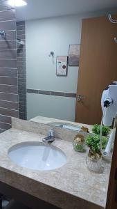 a bathroom counter with a sink and a mirror at Flat Aconchegante - Park Veredas 417 in Rio Quente