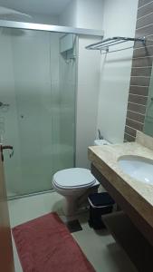 a bathroom with a toilet and a shower and a sink at Flat Aconchegante - Park Veredas 417 in Rio Quente