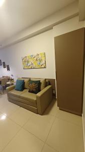 a living room with a couch and a painting on the wall at Flat Aconchegante - Park Veredas 417 in Rio Quente