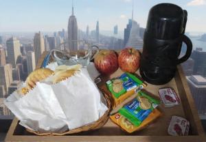 a table with two baskets of food and apples on a window at Hotel Styllus in São Paulo