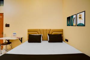 a bedroom with a bed and a table at Hotel O Utsav In in Jabalpur +21 photos
