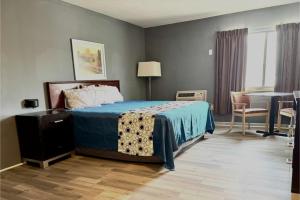 a bedroom with a bed and a table and a desk at Highlander Inn Cleveland Beachwood Near I-480 in North Randall
