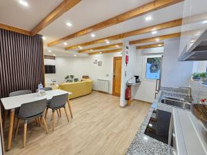 a kitchen and living room with a table and chairs at Celeiro do Avô in Santana