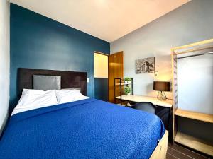 a blue bedroom with a bed and a desk at R&A Hostal in Mexico City