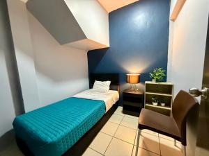 a small room with a bed with a blue wall at R&A Hostal in Mexico City