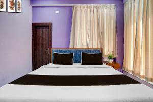 a bedroom with a large bed with purple walls at Hotel O Regal Retreat in Rānchī