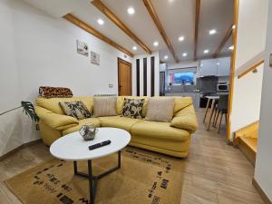 a living room with a yellow couch and a table at Celeiro do Avô in Santana