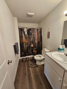 a bathroom with a toilet and a shower curtain at Earl Street Retreat Unit A in Stanfield