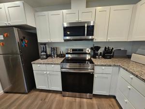 a kitchen with white cabinets and a stove and a microwave at Earl Street Retreat Unit A in Stanfield +27 photos