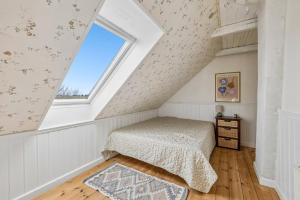 a bedroom with a bed and a window at Lakehouse in Vester Vandet