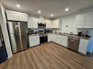 a kitchen with white cabinets and a stainless steel refrigerator at Earl Street Retreat Unit A in Stanfield