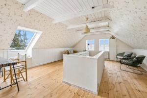 a kitchen and dining room with a table and chairs at Lakehouse in Vester Vandet