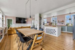 a kitchen and living room with a wooden table and chairs at Lakehouse in Vester Vandet