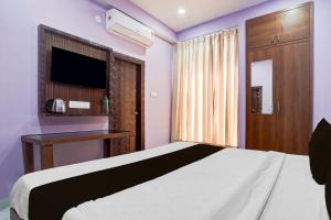 a bedroom with a white bed and a tv at Hotel O Regal Retreat in Rānchī