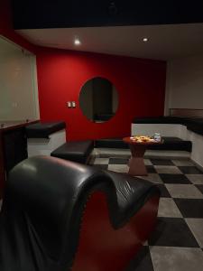 a waiting room with black chairs and a red wall at DLUXE Auto Hotel ADULTS ONLY in Veracruz