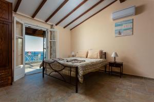 a bedroom with a bed with a view of the ocean at BOHALI'S HOUSE in Agios Gordios
