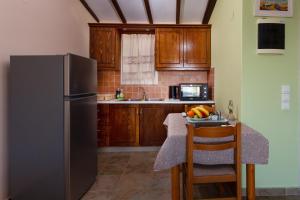 a kitchen with a refrigerator and a table with a bowl of fruit at BOHALI'S HOUSE in Agios Gordios