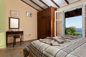 a bedroom with a bed and a desk and a window at BOHALI'S HOUSE in Agios Gordios