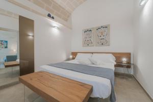 a bedroom with a large bed with a wooden table at Setteminne Resort Design in Favignana