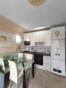 a kitchen with a glass table and white cabinets at Apartment Parque Royal Costa Adeje in Adeje