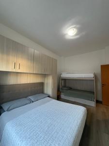 a bedroom with a bed with a white bedspread and cabinets at Casa del Pepo in Segrate