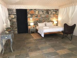a bedroom with a bed and a stone wall at The chocolate frog in Thūr