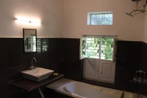 a bathroom with a sink and a tub and a window at The chocolate frog in Thūr