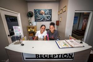 a man and a woman sitting at a counter at Sandbar Beachfront Hotel & Hostel Restaurant in San Pedro +28 photos