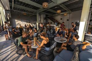 a group of people sitting in chairs playing chess at Sandbar Beachfront Hotel & Hostel Restaurant in San Pedro