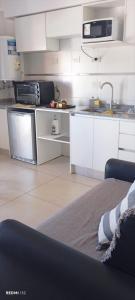 a kitchen with white cabinets and a sink and a microwave at Apart del Centro 03 cochera opcional in Santa Fe +17 photos