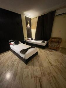 a room with two beds and a chair in it at SINGAPOUR MAROC in Casablanca