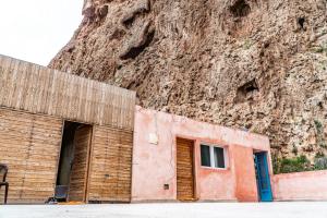 a building next to a mountain with a wall at Gite Skoura in Caïd Bou Malla