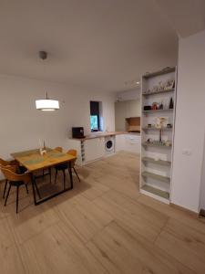 a kitchen and dining room with a table and a table and chairs at Casa David in Băile Govora