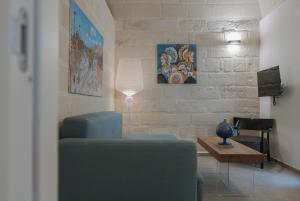 a living room with a blue chair and a table at Setteminne Resort Design in Favignana