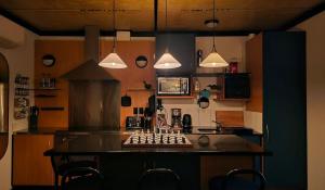 a kitchen with a counter with chairs and pendant lights at Algo Azul Something Blue in Wellington