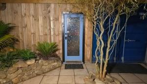 a blue door of a house with a stone wall at Algo Azul Something Blue in Wellington