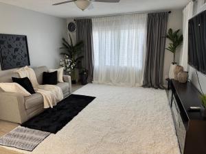 ein Wohnzimmer mit Sofa und Fernseher in der Unterkunft Raqsea Condo in Hampton