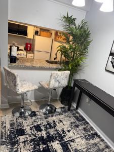 ein Wohnzimmer mit zwei Stühlen und einer Theke in der Unterkunft Raqsea Condo in Hampton