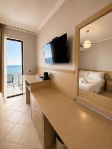a hotel room with a bed and a mirror at Hotel President in Shëngjin