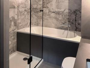 a bathroom with a tub and a toilet at FARFA Harmonia Oliwska in Gdańsk