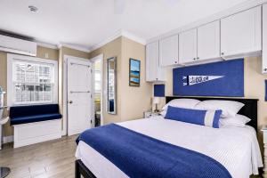 a bedroom with a blue and white bed and a kitchen at Waterfront Studio - Bay Views, Steps to Comm St in Provincetown
